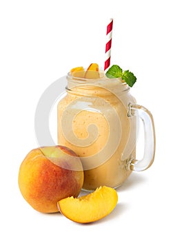 Peach smoothies in a glass jar with fresh fruits on a white background