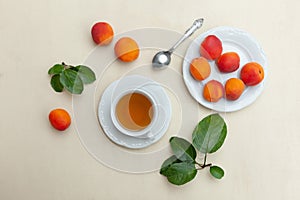 Peach tea in white cup with fresh peaches flatlay on the table