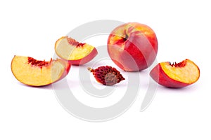 Peach whole and cut into four quarters on a white background isolated close up