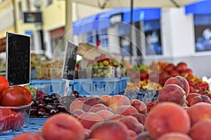 Peaches and cherries and other fruit and vegetables for sale at local farmers market. Fresh organic produce for sale at