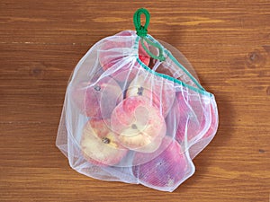 Peaches in ecological packaging. Reusable bags for vegetables and fruits. Shopping in the store, retail. Eco friendly packaging of