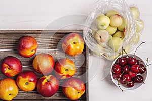 Peaches, nectarines and cherries on a white background.