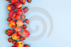 Peaches and strawberries on a blue background. Copyspace