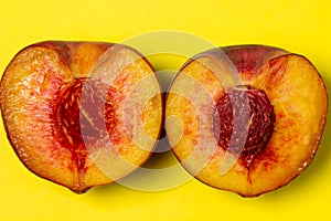 Peaches on a yellow background. Peach cut in half.