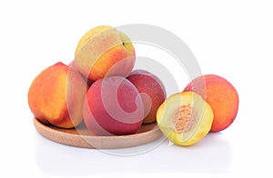 Peachs in wooden plate isolated on white background