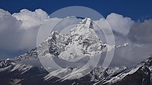Peak of Ama Dablam surrounded by clouds photo