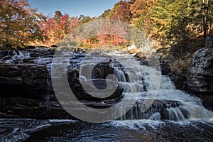 Peak fall foliage surrounds beautiful cascading lower Shohola Falls