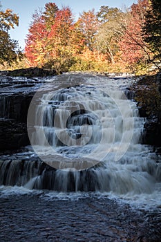 Peak fall foliage surrounds beautiful cascading lower Shohola Falls