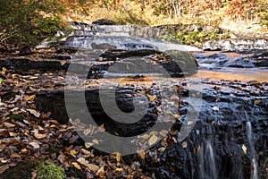 Peak fall foliage surrounds beautiful cascading middle Shohola Falls