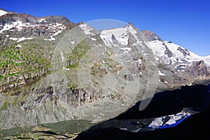 The peak of Grossglockner mountain is reflected in the water collected from the melting Pasterze glacier.