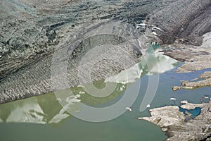 The peak of Grossglockner mountain is reflected in the water collected from the melting Pasterze glacier.