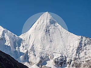 Peak Jambeyang snow mountain with blue sky background photo