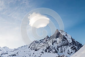 Peak of Mount Machapuchare or popularly known as Fish Tail with a piece of cloud over it as viewed from Annapurna Base Camp, Nepal