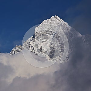 Peak of Mount Thamserku reaching out of the clouds. Nepal