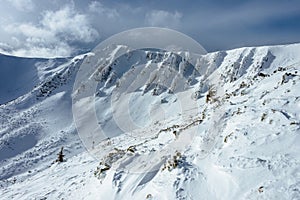 Peak of the Mountain. Beautiful landscape on the cold winter day. View of high mountains with snow white peaks.