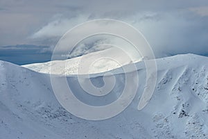 Peak of the Mountain. Beautiful landscape on the cold winter day. View of high mountains with snow white peaks.