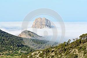 Peak of the mountain is vedra peeping through the fog one autumn morning in Sant Josep de Sa Talaia, Ibiza. photo