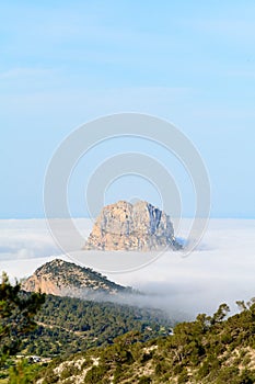 Peak of the mountain is vedra peeping through the fog one autumn morning in Sant Josep de Sa Talaia, Ibiza. photo