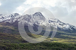 Peak with Utah Snow capped mountains with rolling green hills