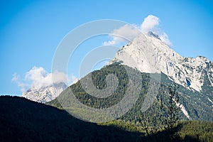 peaks of the wetterstein mountains in the clouds in the early morning, view from mittenwald town