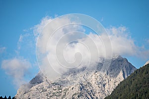 peaks of the wetterstein mountains in the clouds in the early morning, view from mittenwald town