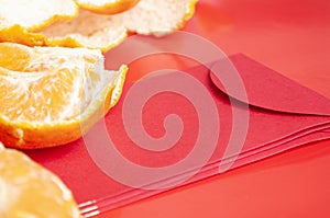 Peal Mandarin oranges and Chinese New Year red packet. Chinese New Year celebration concept