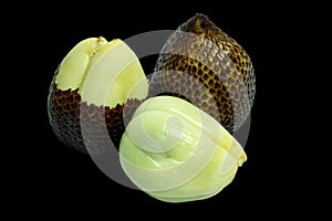 Pealed snakefruit and unpeeled snake fruit isolated on black background, clipping path included