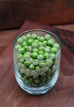 Pean green in bottle glass on wooden background