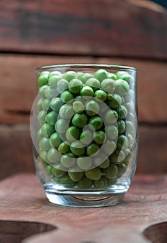 Pean green in bottle glass on wooden background