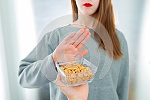 Peanut allergy concept - food intolerance. Young girl refuses to eat peanuts