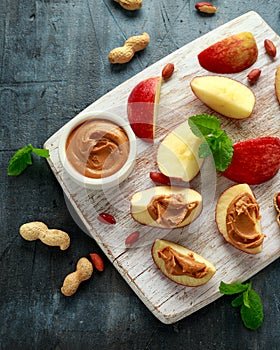 Peanut butter and apple to snack. on white wooden board