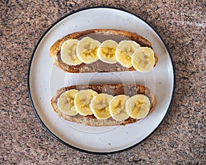 Peanut butter and banana sandwiches, healthy snack on a round plate
