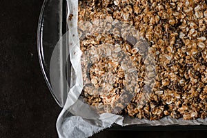 peanut butter chocolate chip granola bars with oats on white parchment paper with neutral background