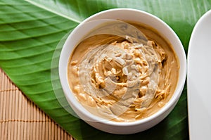 Peanut butter and crushed peanuts in a white bowl