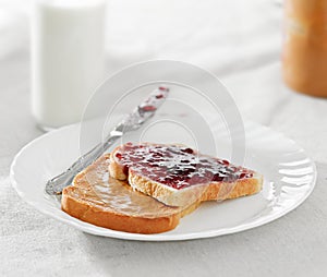 Peanut butter and jelly on pieces of bread.