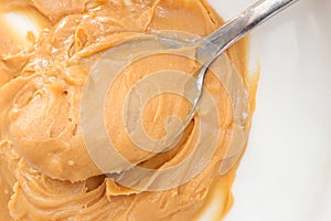 Peanut butter texture. Creamy peanut butter and spoon. Tasty peanut butter