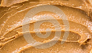 Peanut butter texture swirls background. Creamy smooth peanut butter backdrop, organic food