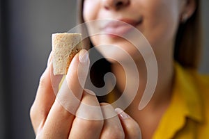 Peanut candy (pacoca). Extreme close-up of beautiful girl holding Pacoca traditional Brazilian peanut-based candy