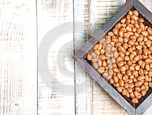 Peanut in a cup on a wooden background