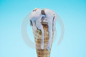 Peanut flavor ice cream cone melting on a blue