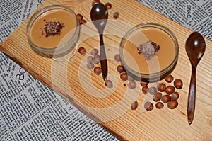 Peanut-flavored pudding in glass cups on a wooden board