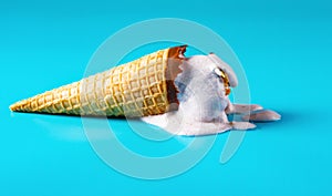 Peanut ice cream cone in melting process on blue background