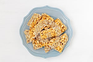 Peanut indian chikki kozinaki on plate on white background, top view