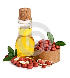 Peanut oil in a glass bottle with peanuts in bowl