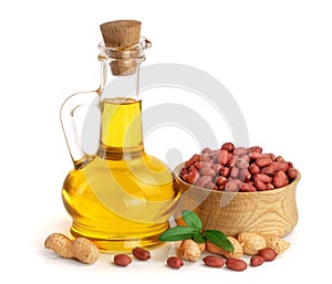 Peanut oil in a glass bottle with peanuts in bowl