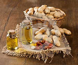 Peanut oil and nuts on a wooden table