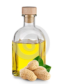 Peanut oil in transparent bottle and peanuts with leaves