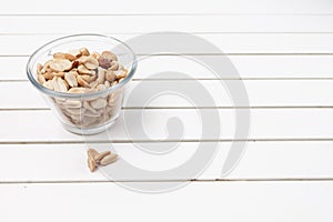 Peanuts in a bowl over a white rustic table