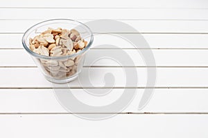 peanuts in a bowl over a white rustic table