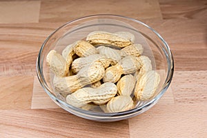 Peanuts on bowl on wood in beech